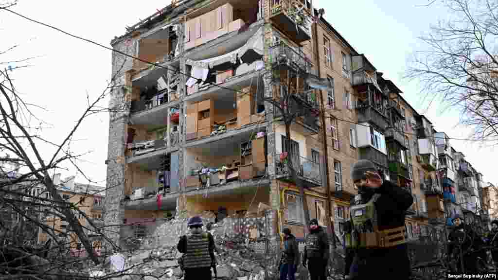 UKRAINE -- Ukrainian policemen secure the area by a five-storey residential building