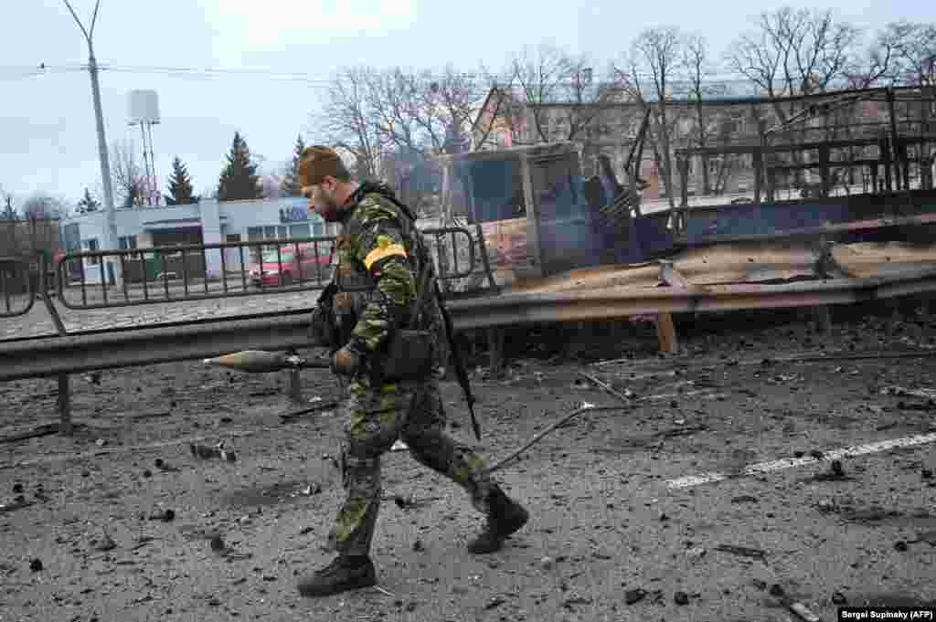 Украинский военнослужащий несет гранатомет, оставшийся после боя в Киеве, 26 февраля 2022 года