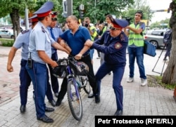 Полиция задерживает мужчину на велосипеде в центре Алматы, где ожидался несанкционированный митинг. 10 июня 2019 года