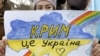 Девушка держит рисунок во время митинга в Крыму, 10 марта 2014 года