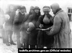 Крестьяне получают пшено на трудодни в колхозе имени Д. Бедного в с. Удачное Гришинского района Донецкой области Место и дата съемки: с. Удачное, 1930-е годы